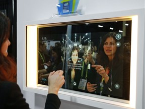 A woman demonstrates the Artemis smart mirror at the CareOS booth during CES Unveiled at CES International, Sunday, Jan. 6, 2019, in Las Vegas. The interactive mirror has video capture, virtual try-ons, facial and object recognition, and can give the user video instruction on specific makeup products, among other things.