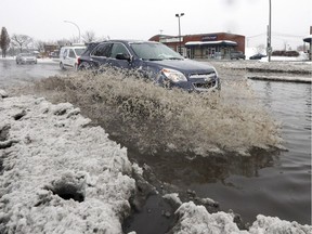 A car drives through the flooded intersection of Pierrefonds Blvd. and Sources Blvd. on Jan. 24.