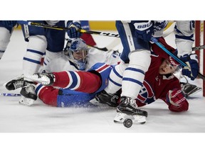 Canadiens' Jesperi Kotkaniemi and Toronto Maple Leafs goaltender Frederik Andersen both try to keep an eye on the puck after being knocked to the ice in Montreal on Saturday, Feb. 9, 2019.