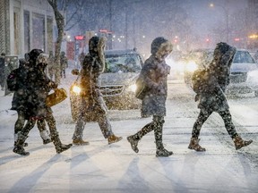 Pedestrians cross Peel St. in downtown Montreal at the beginning of a major storm Tuesday, Feb. 12, 2019, that was expected to drop 30 to 40 centimetres of snow on Montreal overnight.