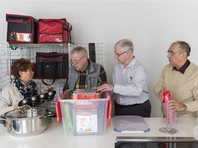 Dollard-des-Ormeaux Meals on Wheels volunteers, from left, Elisa Canson, Bob Pearson, Richard Berry and Ion Duceac sort through kitchen utensils at the Dollard Civic Centre.