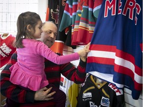 Paul Bayer and his four-year-old daughter, Audrey, get a closer look at the hockey sweaters on display at Stewart Hall on Saturday.