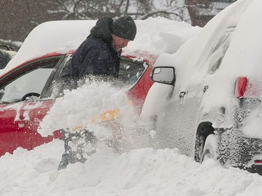 Ronald Lavis digs out a car in Ville St Laurent, Montreal, Monday February 13, 2017, following a snowstorm that dumped up to 23cm of snow in some places.