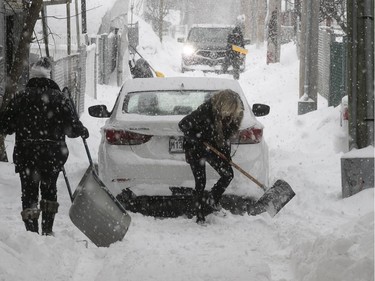 Montreal residents try to get their cars out of lanes near Papineau and Jean-Talon Feb. 13, 2019.