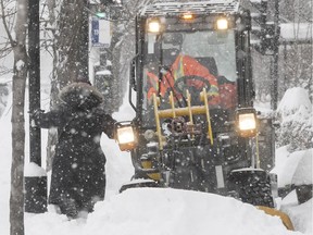 A pedestrian walks past a sidewalk cleaner at Christophe-Colomb Ave. and Jean Talon St., on Wednesday February 13, 2019.