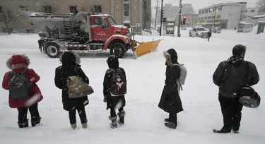 Montrealers wait for a bus at Papineau and Jean-Talon Feb. 13, 2019.