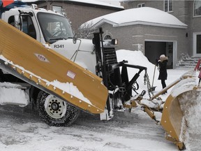 A town of Dollard crew helps Nicol Bitensky clear the edge of her driveway on Tobago St. last Wednesday following a overnight snow storm.