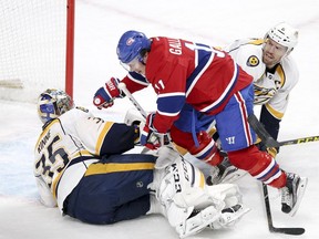 Montreal Canadiens' Brendan Gallagher falls over Nashville Predators goalie Pekka Rinne after scoring a goal despite a check by defenceman Shea Weber in Montreal on Feb. 22, 2016.