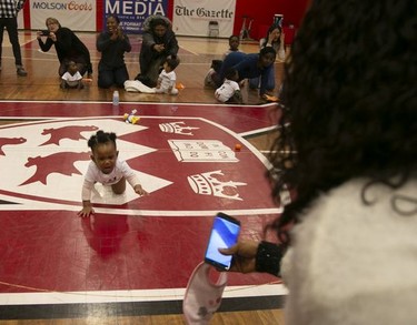 7-month-old Alexandra Akinrinola crawls towards her mom Josephine and the finish line during a baby race in Montreal on Feb. 23, 2019.