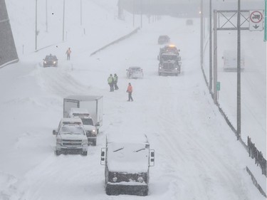 SQ officers and safety crews try to clear up Highway 13 near Cote de Liesse road on Wednesday March 15, 2017 following massive snow storm that left many motorists stranded overnight.