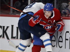 Canadiens forward Brendan Gallagher tries to break free as the Winnipeg Jet' Bryan Little pins him to the boards during NHL game at the Bell Centre in Montreal on April 3, 2018.