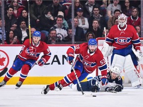 Kyle Connor of the Winnipeg Jets trips Canadiens' Victor Mete as Jonathan Drouin comes up the ice Thursday night at the Bell Centre.