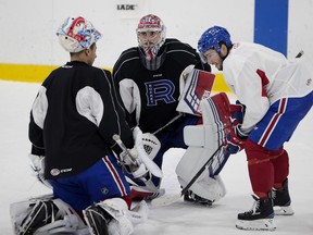 Laval Rocket's Daniel Audette, right, chats with goaltender Charlie Lindgren and Michael McNiven, left, during a practice in Montreal on Nov. 6, 2018.