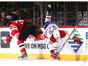 Canadiens' Artturi Lehkohen is checked by Kurtis Gabriel of the New Jersey Devils at the Prudential Center on Monday, Feb. 25, 2019, in Newark, N.J.