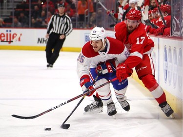 Andrew Shaw #65 of the Montreal Canadiens battles for the puck with Filip Hronek #17 of the Detroit Red Wings during the first period at Little Caesars Arena on February 26, 2019 in Detroit, Michigan.