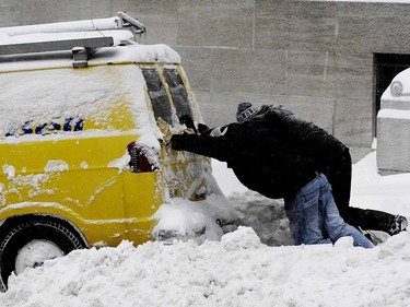 On Dec. 3, 2007, two men come to the aid of a Bell service van on Beaver Hall, Montreal, during the first snowstorm of winter.