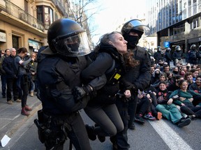 Catalan regional police forces Mossos d'Esquadra escort a student as they begin to disperse students blocking a street in Barcelona to protest against the trial of former Catalan separatist leaders on February 12, 2019. - Twelve former Catalan leaders go on trial at Spain's Supreme Court for their role in a failed 2017 bid to break away from Spain.