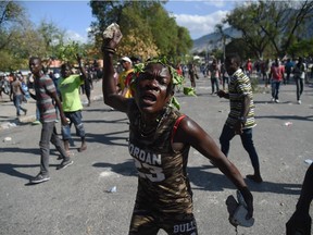 A demonstrator gestures during clashes in front of the National Palace, in the centre of Haitian capital Port-au-Prince, Feb. 13, 2019.