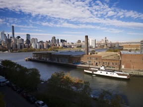 In this Nov. 7, 2018, file photo, a rusting ferryboat is docked next to an aging industrial warehouse on Long Island City's Anable Basin in the Queens borough of New York.