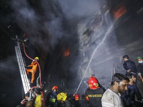 Firefighters work to douse flames in Dhaka, Bangladesh, Thursday, Feb. 21, 2019. A devastating fire raced through at least five buildings in an old part of Bangladesh's capital and killed scores of people.