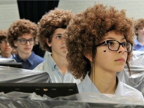 Madison Middle School art student Ariceli Martinez, wearing her Bob Ross wig, listens to the artist speak on a video screen before painting began on Flash Bob Flash Mob Day on Feb. 7, 2019 in Abilene, Texas