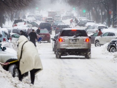 Mile-End residents shovel their cars on St. Urbain boulevard during a snowstorm with mixed snow and ice pellets in Montreal on Sunday, December 22, 2013.