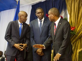 Men at the centre of Haiti's government: Prime Minister Jean-Henry Ceant, right, talks to Haiti's President Jovenel Moise, left, and Senate President Joseph Lambert in August 2018. Haitians have vowed to keep protesting until Moise resigns.