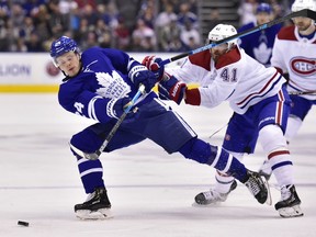 Toronto Maple Leafs' Kasperi Kapanen and Canadiens' Paul Byron  battle for the puck in Toronto on Saturday, Feb. 23, 2019.