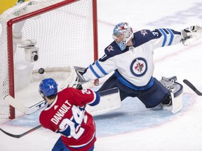 Montreal Canadiens centre Phillip Danault  scores the fourth goal against Winnipeg Jets goaltender Connor Hellebuyck during third period on Thursday, February 7, 2019, in Montreal.