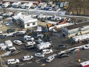 First responders and emergency vehicles are gathered near the scene of a shooting at an industrial park in Aurora, Ill., on Friday, Feb. 15, 2019.