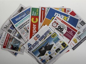 A pile of printed advertising flyers from a Publisac in 2014.