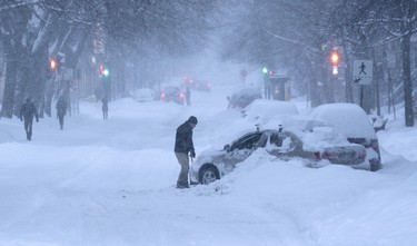 A man tries to get his car out that is stuck in a snowbank during a winter storm in Montreal Feb. 13, 2019.