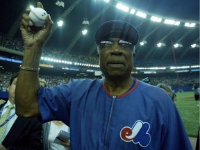 Montreal Expos manager Frank Robinson tosses balls to fans after the team's final match in Montreal against the Florida Marlins on Sept. 29, 2004.