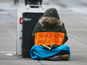 A homeless person panhandles in downtown Calgary.