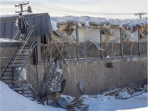 A worker looks over the scene after heavy snow accumulation caused the roof of a two-storey building to collapse in St-Jérôme on Feb. 17.