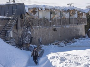 A worker looks over the scene after heavy snow accumulation caused the roof of a two-storey building to collapse, Sunday, February 17, 2019 in St-Jérôme.