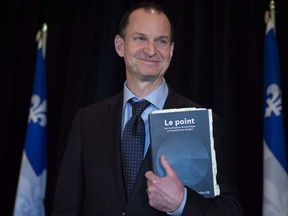 Quebec Finance Minister Eric Girard holds a copy of a document as he presents a financial update Monday, Dec. 3, 2018 in Quebec City. Francois Legault's Coalition Avenir Quebec government will table its first budget March 21.