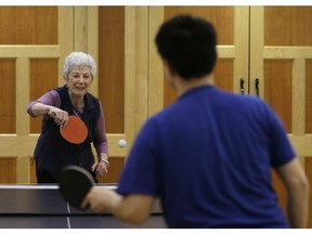 In this Friday, Feb. 17, 2017 photo, Ilona Engel Travis, left, and Rixiang "Ricky" Huang play ping-pong at Judson Manor, in Cleveland. In a research project, graduate-level students from the Cleveland Institute of Music and the Cleveland Institute of Art live among residents of the Judson Manor retirement home. The study looks at the impact of isolation and loneliness, aging and stereotypes of retirees by students and vice versa. Huang is an artist-in-residence at Judson Manor. He is a Cleveland Institute of Music undergraduate student studying music.