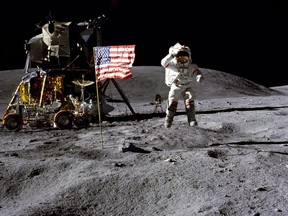 In this April 1972 photo made available by NASA, John Young salutes the U.S. flag at the Descartes landing site on the moon during the first Apollo 16 extravehicular activity. NASA says the astronaut, who walked on the moon and later commanded the first space shuttle flight, died on Friday, Jan. 5, 2018. He was 87. (Charles M. Duke Jr./NASA via AP) ORG XMIT: NYJY102