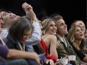 Eugenie Bouchard, left, poses for photographs with her blind date, John Goehrke, right, during the NBA game between the Brooklyn Nets and the Milwaukee Bucks Feb. 15, 2017, in New York. After losing a Super Bowl bet on Twitter Bouchard agreed to go on a date with a random fan.