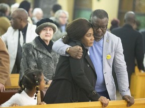 Kouadio Frédéric Kouakou hugs wife Akouena Noëlla Bibie while their daughter looks on during mass, which the family attended in honour of their missing son Ariel, at Eglise Saint-Joseph-de-Bordeaux in Ahuntsic, March 12, 2019.