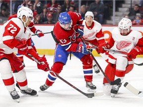 Montreal Canadiens forward Jordan Weal loses puck to Detroit Red Wings' Andreas Athanasiou, left, while being defended by Wings Filip Hronek in Montreal on March 12, 2019.