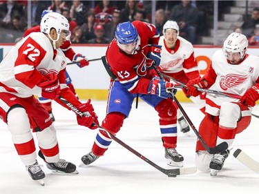 Montreal Canadiens' Jordan Weal has the puck taken away from him by Detroit Red Wings Andreas Athanasiou, left, while being defended by Wings Filip Hronek during first period of National Hockey League game in Montreal Tuesday March 12, 2019.