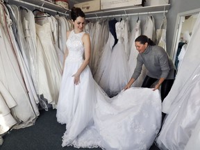 Carol de Sevigne helps her daughter Claire try on a previously-worn wedding dress at the Maison NOVA store in Hudson.