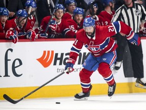 Montreal Canadiens' Nate Thompson moves the puck in front of the Habs' bench during second period against the  New York Islanders in Montreal on March 21, 2019.