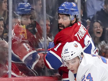 Canadiens' Nate Thompson bounces off a check by Islanders' Scott Mayfield during first period Thursday night at the Bell Centre.