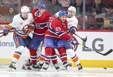 Montreal Canadiens' Andrew Shaw, #65, and Arturi Lehkonen battle New York Islanders' Ryan Pulock, left, and Adam Pelech in front of the Islanders goal during second period of National Hockey League game in Montreal Thursday March 21, 2019.
