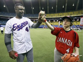 Former Montreal Expos pitcher Ken Hill teaches Vanessa Riopel how to throw a curveball during Play Ball event held in Montreal Saturday March 23, 2019 in recognition of the centennial of Jackie Robinson's birth.  Riopel is a former member of Canada's women's baseball national team.