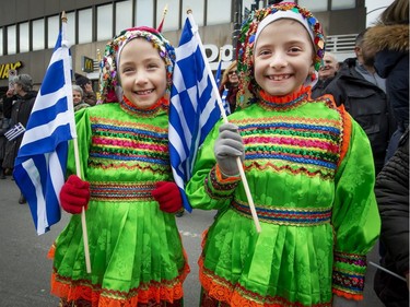 7 year old twins Mikaella left, and Evyenia Kouzelis right, dressed in traditional Greek dress, wait to march along Rue Jean Talon during the Hellenic Community of Greater Montreal's annual Greek Independence Day Parade in Montreal, on Sunday, March 24, 2019.