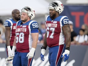 Montreal Alouettes' Luc Brodeur-Jourdain and Tony Washington (67) take part in the pre-game warmup before facing the Toronto Argonauts in Montreal on Aug. 24, 2018.